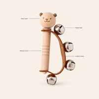 Bear Bell Rattle features: Natural wood, Bear head, Metal bells, Leather strap